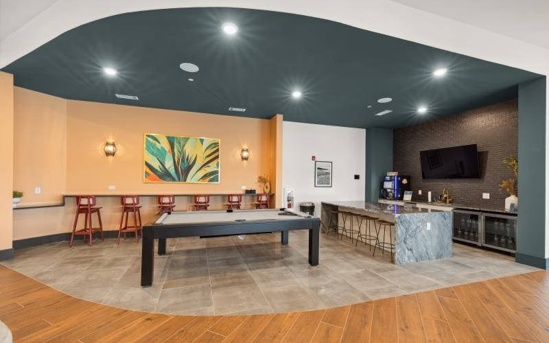 a room with a pool table and chairs