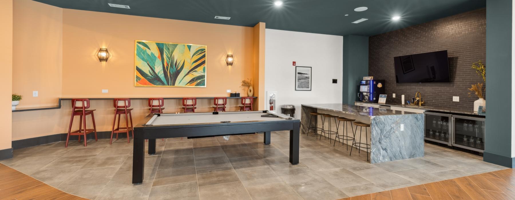 a room with a pool table and chairs