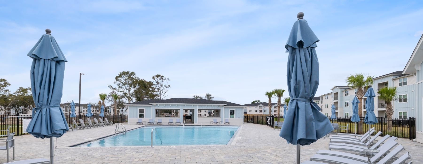a pool with chairs and umbrellas